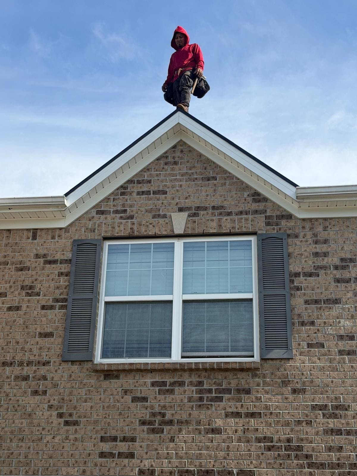 Checkered Flag Roofing crew members working at the gable peak of a roof in Avon, Indiana