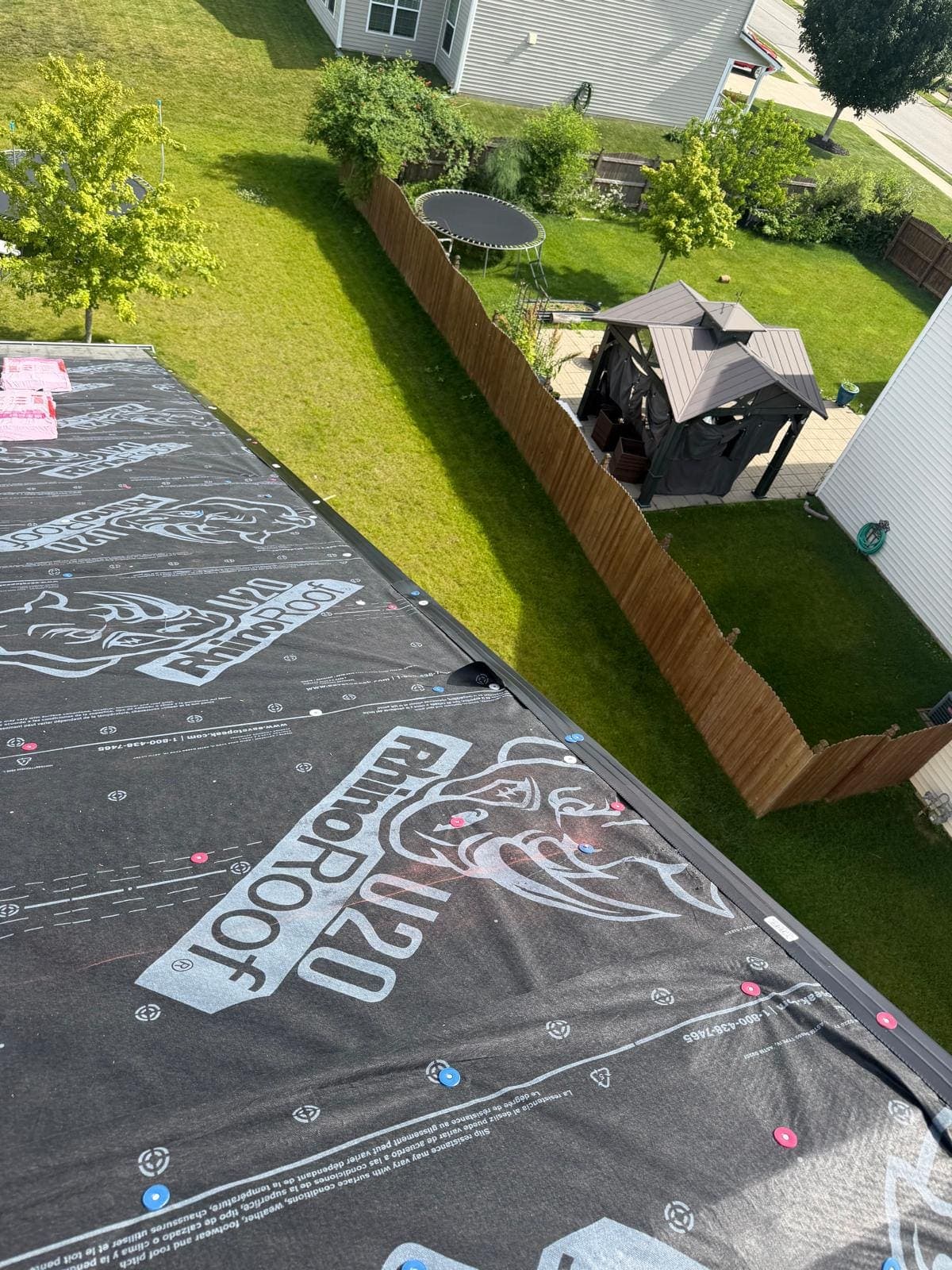 Backyard view of a West Haven home mid-roof-replacement with underlayment on the slope