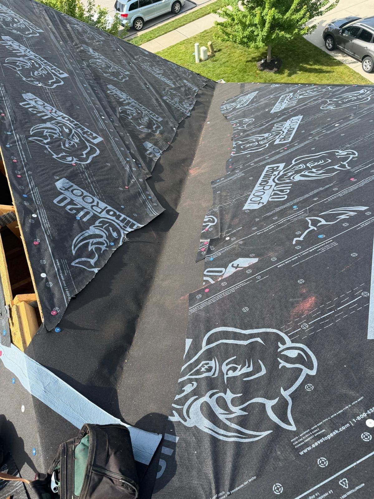 Synthetic RhinoRoof underlayment fastened across roof decking, close view of the capped nails